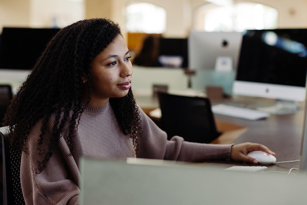 a graphic design student sitting at a computer